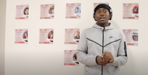 African American student Robert Scott in grey hoodie and black cap and headphones looks skyward and speaks